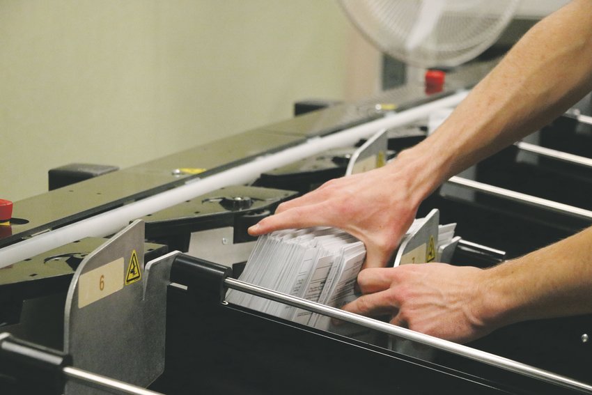 A Douglas County elections worker grabs a stack of acceptable ballots from the sorting machine, located in the basement of the headquarters building Friday, Nov. 1.