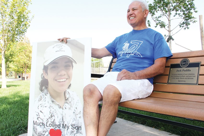 Rick Padilla, father of Jack Padilla, sits on a bench dedicated to his son at Village Greens Park near Cherry Creek High School on Sept. 8. He holds next to him a large photo of Jack, a 15-year-old Cherry Creek High freshman who took his own life in February. A City of Greenwood Village engraving on the bench reads: “In joyous memory of your charisma, your kindness to others, and your love of life, family, friends and lacrosse. #jackstrong.”