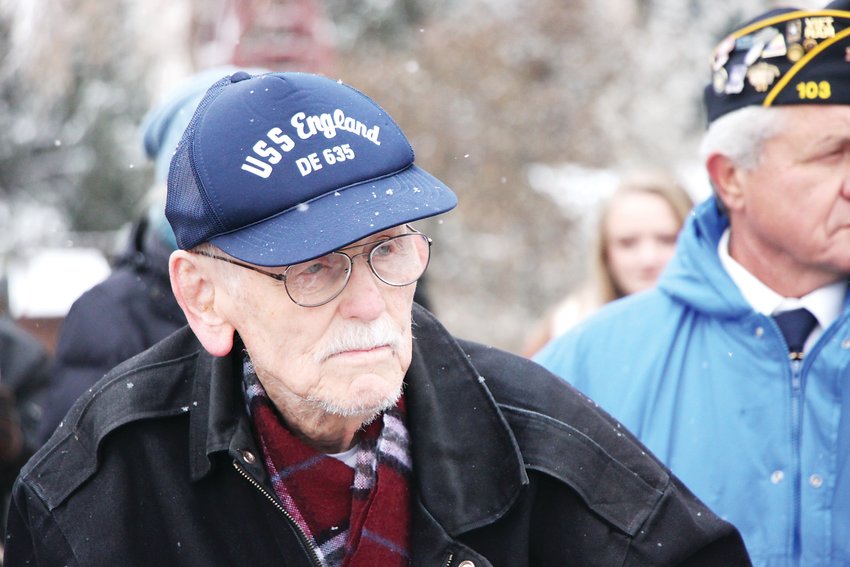 Charles Goodwin stands as a choir performs “Anchors Aweigh,” the march song of the United States Navy. Goodwin, 96, was the sole World War II veteran in attendance at the ceremony.