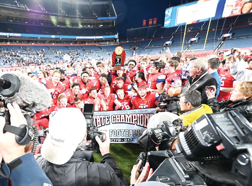 The Cherry Creek football team raises the championship trophy and banner after defeating Columbine 35-10 on Dec. 7 at Empower Field at Mile High.