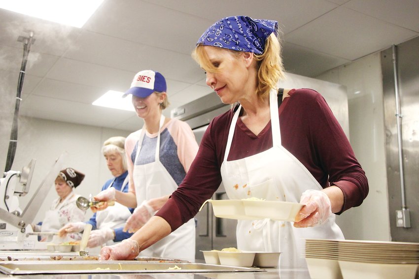 Kelly Eisen and fellow Meals on Wheels volunteers prepare a spaghetti lunch on Jan. 6. TLC Meals on Wheels, which provides healthy food and companionship for homebound seniors and others, is up and running in their new home at Broadway and Arapahoe Road.