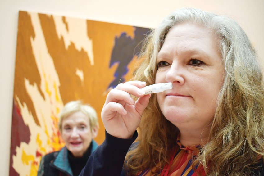 A woman smells a vial as part of the Stimulate Your Senses exhibit at the Clyfford Still Museum. The exhibit uses different materials to engage all five senses of guests at the museum.