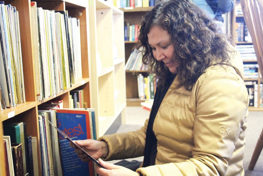 Anna Nicks goes through old records at Global Thrift. The thrift store is operated by volunteers and benefits Global Refuge, an organization that carries out international projects for refugees.