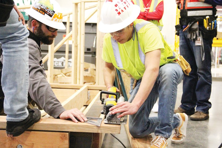 Matthew Danfelser, a Cherry Creek High School senior, right, uses a tool during a Feb. 19 construction class at the Cherry Creek Innovation Campus. Watching over him is Jim Dosky, an infrastructure engineering teacher, left.