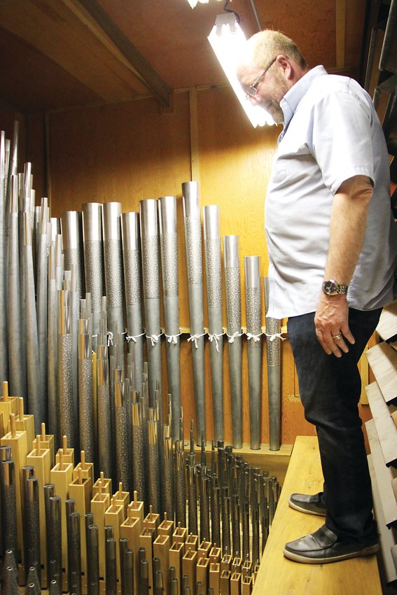 Michael Zehnder, who leads musical worship at Littleton’s Ascension Lutheran Church, stands inside the heart of the church’s 1950s-vintage neo-baroque style pipe organ.