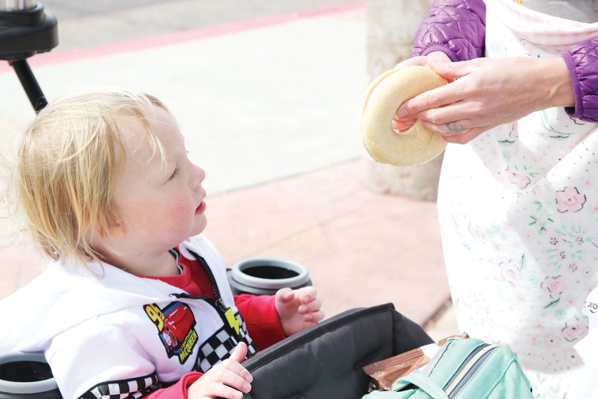Kristen Sortman prepares a bagel for 3-year-old Flynn from the sack lunch they picked up a South Ridge Elementary School on March 23.