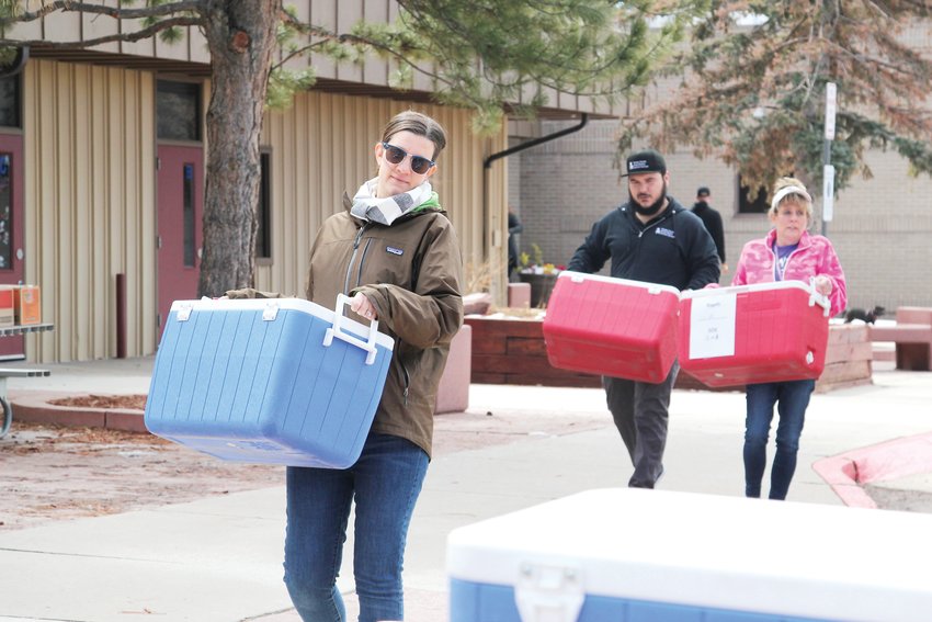 Jen Peifer, manager of operations for Nutrition Services at the Douglas County School District, unloads coolers packed with lunches for children on March 23.