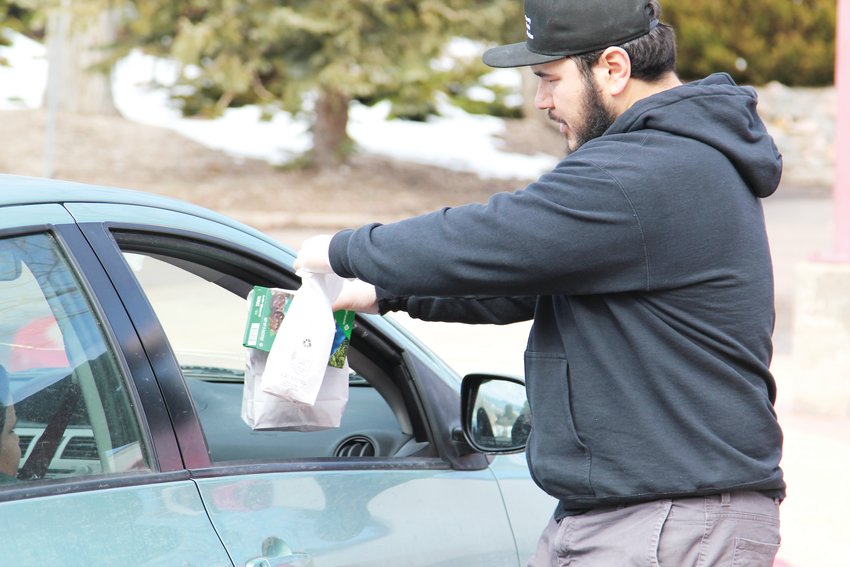 Families picking up lunches from South Ridge Elementary School on March 23 were served in a drive-through manner, as staff handed them the number of meals requested without them needing to get out of their vehicles.