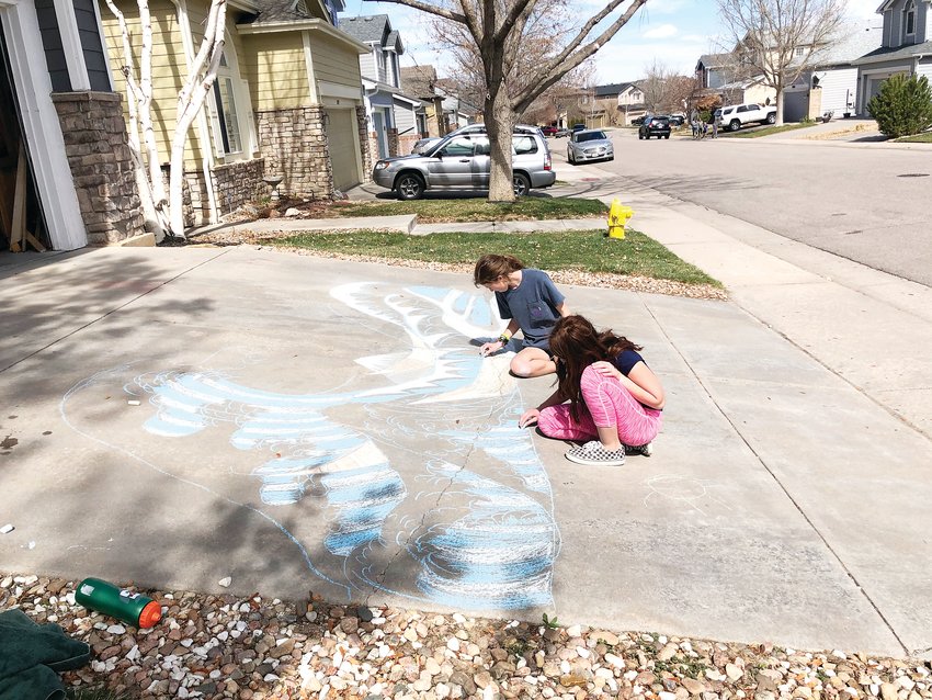 Emma Fisher, 16, and Paige Fisher, 10, work on their chalk art project during a neighborhood driveway event March 25. The sisters were working to replicate the famous Japanese print called "The Great Wave off Kanagawa."