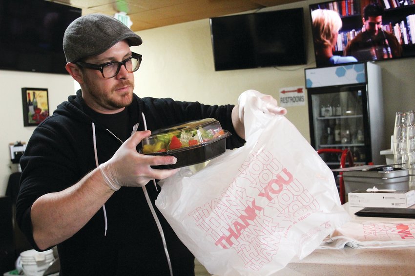 Brian Meadows, co-owner of Gallo Italian Supper Club and Bake, bags up a to go order. Meadows said the restaurant is bringing in a quarter of its average sales.