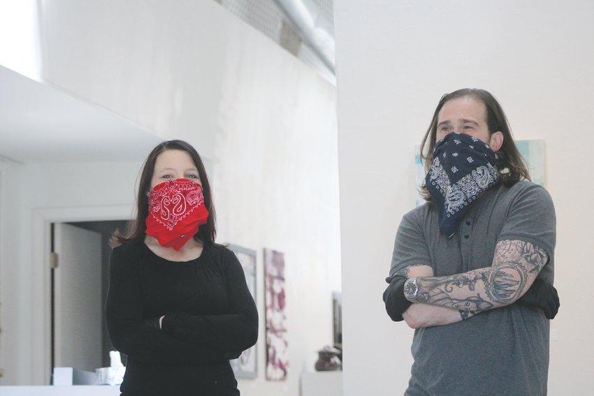 Christy Seving, an artist at NEXT Gallery at the 40 West Arts District, and NEXT Gallery Director Josh Davy pose for a photo at the art gallery. The two wore bandanas as a way to cover their faces. Colorado Gov. Jared Polis has urged Coloradans to wear face coverings to stop the spread of COVID-19.