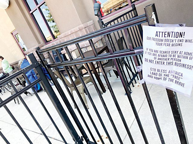 A sign posted on the fence of the exterior patio of C&amp;C Coffee and Kitchen in Castle Rock May 10.
