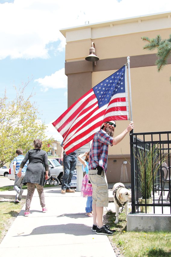 A man named Greg, who preferred not to provide his last name, hangs an American flag outside C&amp;C Coffee and Kitchen on May 12. Greg said he received threatening comments online after he was pictured at the restaurant before.