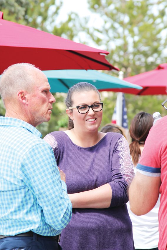 April Arellano, co-owner of C&amp;C Coffee and Kitchen, talks with her husband and guest outside the restaurant on May 12.