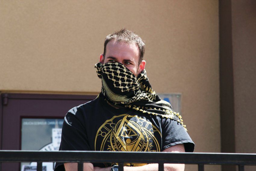 A man who declined to provide his name stands on the C&amp;C Coffee and Kitchen patio on May 12 wearing a face covering during a grill out.