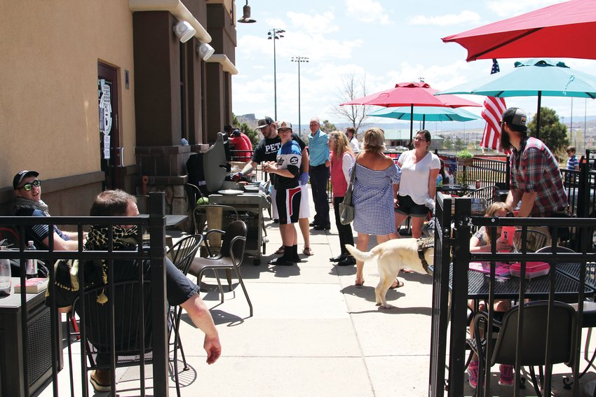 People gathered to the C&amp;C Coffee and Kitchen patio, coming and going for free food on May 12. Few wore masks and more than 10 people socialized during the cookout.
