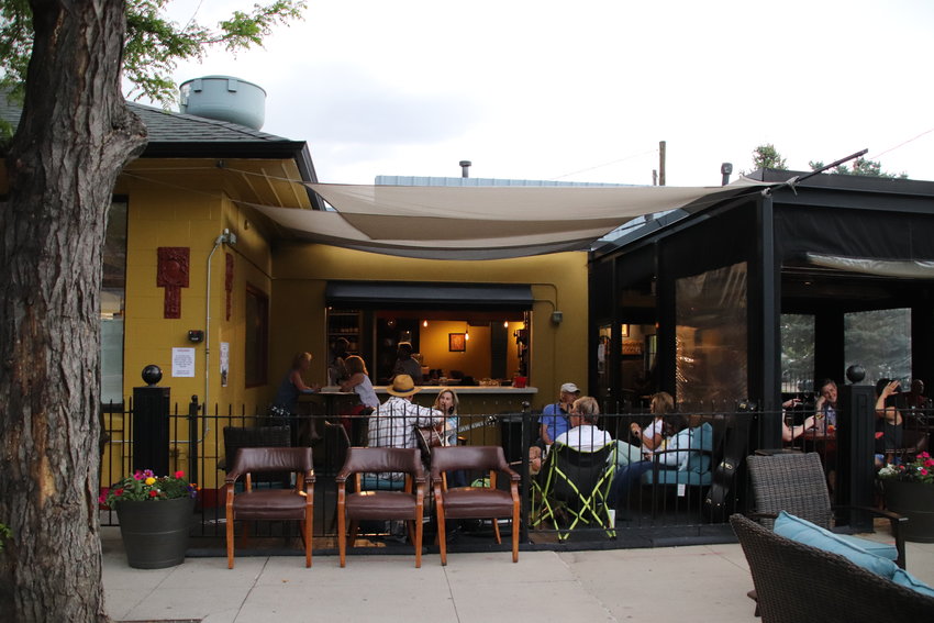 Patrons play guitar at Grande Station on Main Street on May 27. Littleton will soon begin closing Main Street through downtown on weekends to allow restaurants to serve guests at outdoor tables.