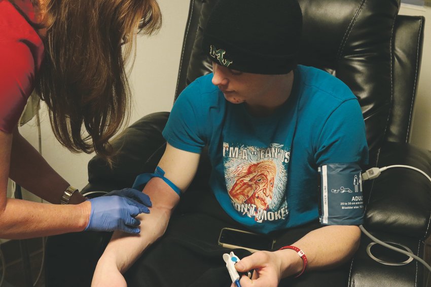 The director of infusion at Alpine Health &amp; Wellness begins an IV line for Patrick Boland as he prepares for a ketamine infusion. The treatment, which Patrick receives every three months, provides significant relief for his nerve pain but eventually wears off.