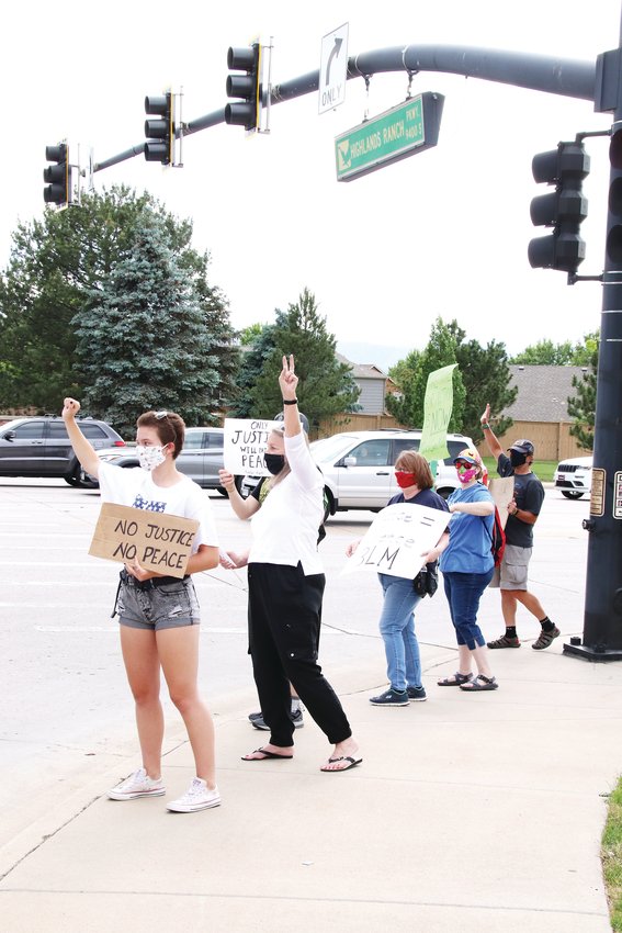 Protesters carrying signs with messages like “Black Lives Matter” and “the time to act is now” stand along the corner of Lucent Boulevard and Highlands Ranch Parkway.