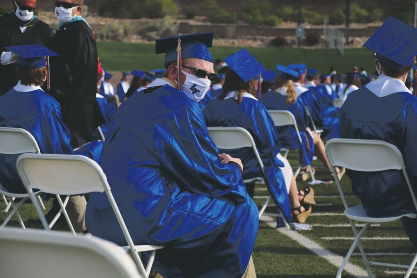 A Legend High School senior awaits the start of the June 25 graduation ceremony while wearing a face mask. Masks were not required at the outdoor event.