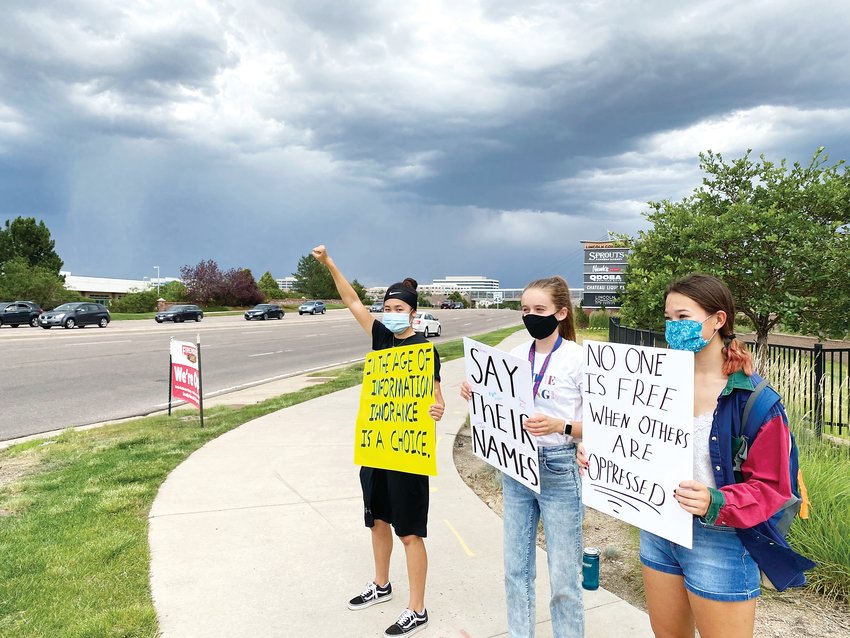 From left, Lexi Bauer, Eileen Kennedy and Maddie Provost stand on the corner of Commons Street and Lincoln Avenue in Lone Tree July 4 in support of the Black Lives Matter movement.