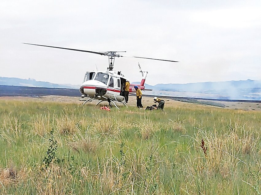 A helicopter lands near Chatfield Reservoir to assist fire crews in a June 29 blaze at the south end of the reservoir.