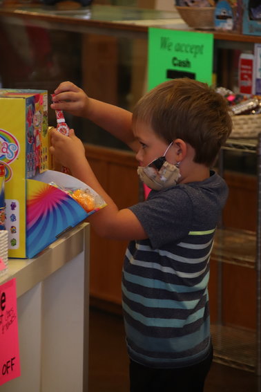 Willard Bone, 4, picks up a watch at Timbuk Toys in Highlands Ranch July 23.