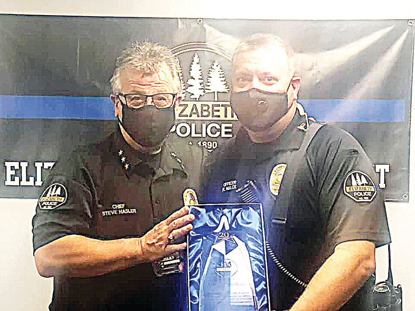 Elizabeth Chief of Police Stephen Hasler presents Officer Kurt Hulce with a plaque recognizing his 20 years of service to the community of Elizabeth as an officer.