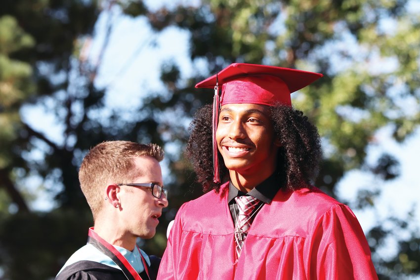 Students walk in front of the crowd after their names are called at Eaglecrest High School’s graduation ceremony July 31 at Cherry Creek High School’s Stutler Bowl stadium.