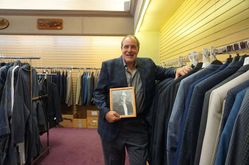 Kaufman's owner Sam Kaufman with a photo of his father, Fred, who opened the tall and big clothing store in 1958.