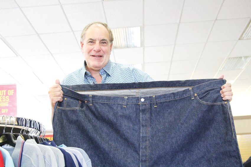 Sam Kaufman, owner of Kaufman's Tall and Big Shop in Englewood, holds a pair of size 76 jeans at his store. After 62 years of being in Englewood, Kaufman's Tall and Big Shop is planning to close its doors at the end of October.