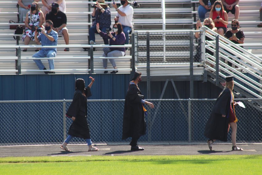 Exiting the field, graduates spot their family members.