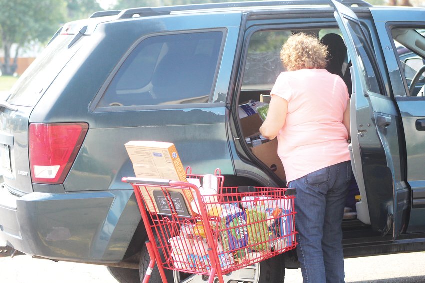 Maria packs food into her car at Community Ministry of Southwest Denver’s food pantry on Aug. 20. She recently lost her house cleaning job because of the pandemic.