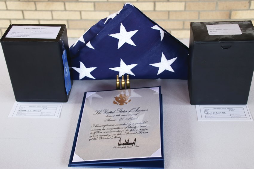 A folded American flag and Presidential Memorial Certificate sit between the containers of Tom Munds' remains, left, and the container of remains of his wife, Alva, at Fort Logan National Cemetery after Munds' memorial service.