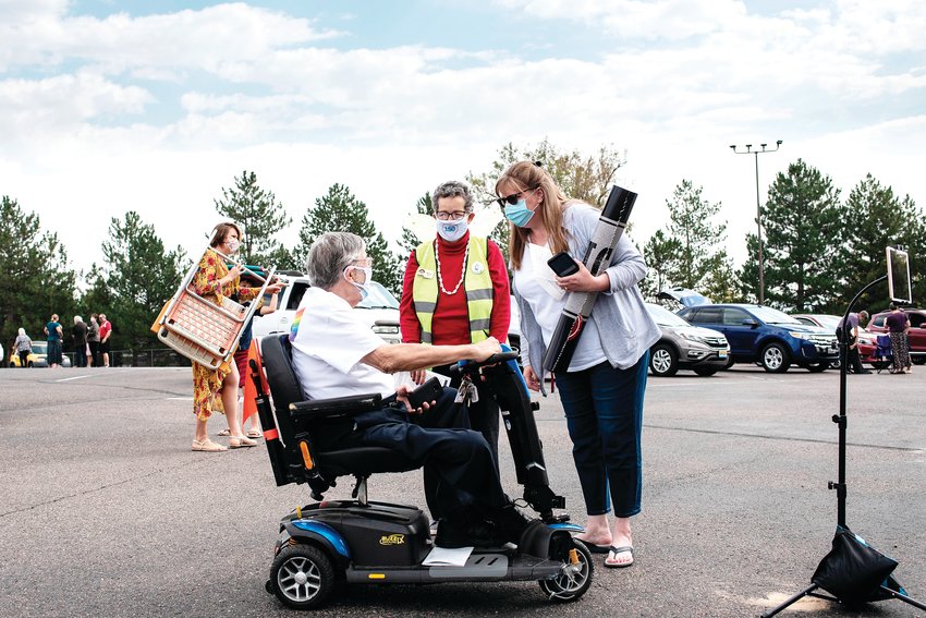 AUMC Members Ben and Maggie Roe speak with staff member Laura Winberg as they get their spot for AUMC’s parking lot service.