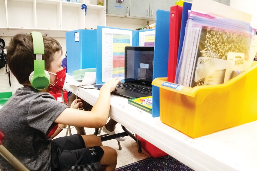 Corbin Smith uses headphones and a laptop during his virtual learning experience at the Shai Learning Labs, which is offered by the Staenberg-Loup Jewish Community Center in Denver.