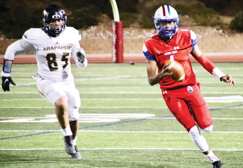 Arapahoe's Jared Ramos (85) chases Cherry Creek quarterback Julian Hammond (1) after he scrambled out of the pocket during the second quarter of the Nov. 6 Centennial League football game. The Bruins, the top-ranked team in the CHSAANow.com 5A poll, defeated the Warriors, 56-7.