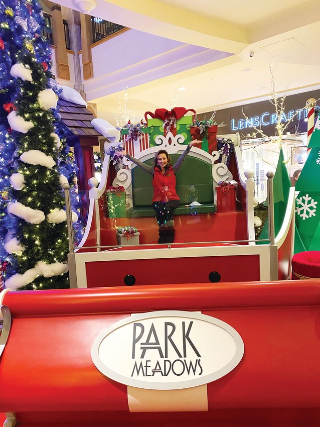 Pam Kelly, senior general manager for Park Meadows, sits atop the new Santa sleigh the mall installed this year for its touchless Santa exhibit.