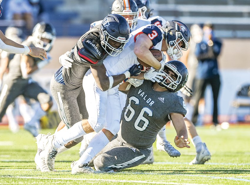 Legend's Connor Eise (3) gets wrapped up by Valor Christian defenders Cayden Hawkins (41) and Nick Chapdelaine (66). The Eagles ended the 5A semifinal with a 45-0 victory over the Titans.