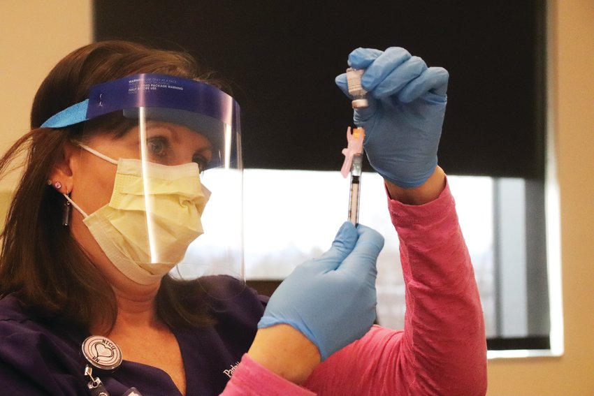 Leonna Larter, a registered nurse at Parker Adventist Hospital, draws the COVID-19 vaccine from its vial into a syringe Dec. 17. The hospital began inoculating frontline staff three days after the state received its first shipment of the Pfizer vaccine.