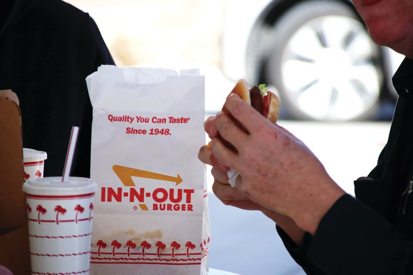 Employees at the new In-N-Out in Lone Tree grab burgers during the restaurant’s Feb. 22 grand opening.