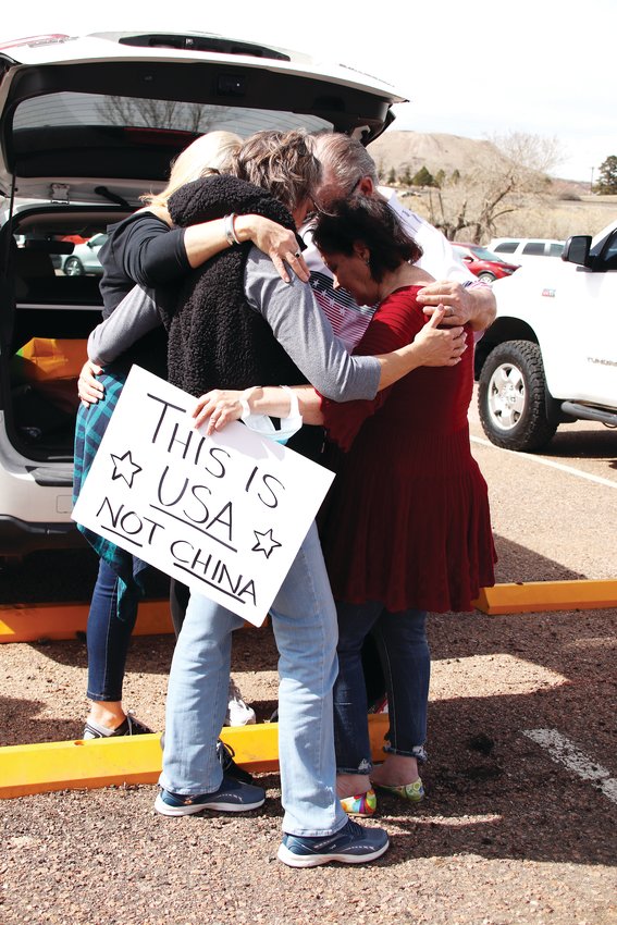 A group of attendees at a March 9 rally in Castle Rock huddle for a prayer. The rally took place before and during a county commissioner meeting.
