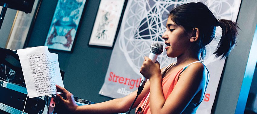 Lyrical Rodriguez, who was 11 at the time the photo was taken in 2016, reads one of her poems during a performance at Art from Ashes.