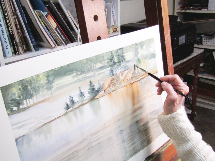 Carol Newsom puts final touches on a painting of the Evergreen Lake House.