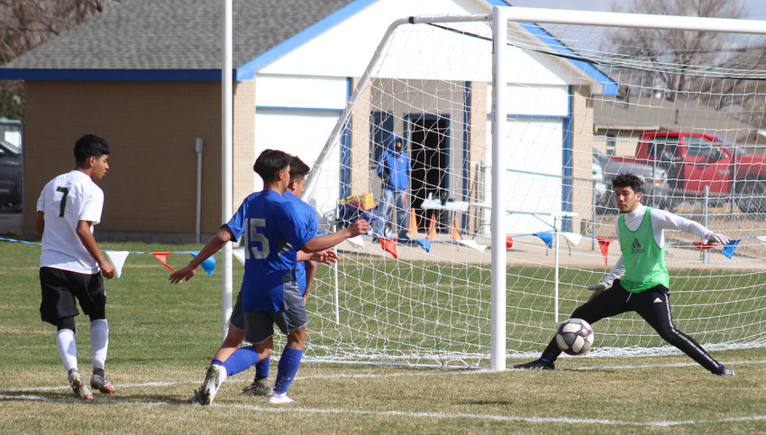 Fort Lupton goalie Dominik Martinez gets his shin on this shot by Aurora Central's Felipe Hernandez April 17. FLHS' Santiago Gonzales is part of the Bluedevils' defensive corps.