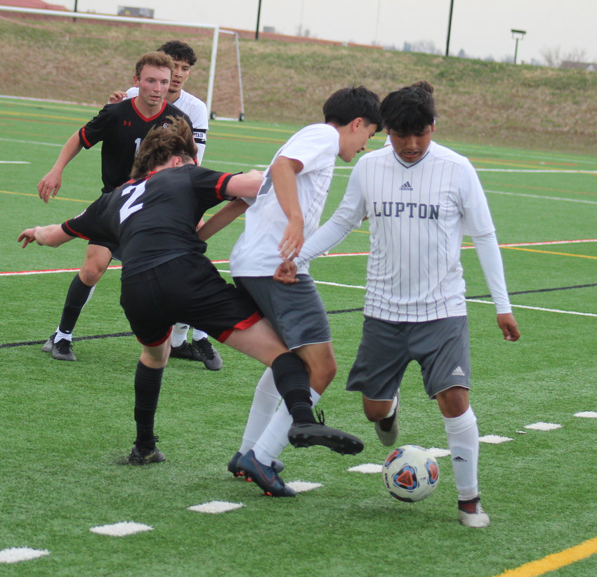 Fort Lupton's Luis Zavala tries to get away from the traffic jam in the first half of his team's state 3A soccer playoff game at Colorado Academy. Zavala's teammate, Jovanny Sixtos gets tangled up with CA's Aaron Rice (2) .
