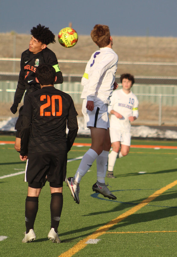 Adams City's Gabriel Ortega gets his head to the ball ahead of the defense of Boulder's Micah Garry during the teams' first-round playoff game April 22.