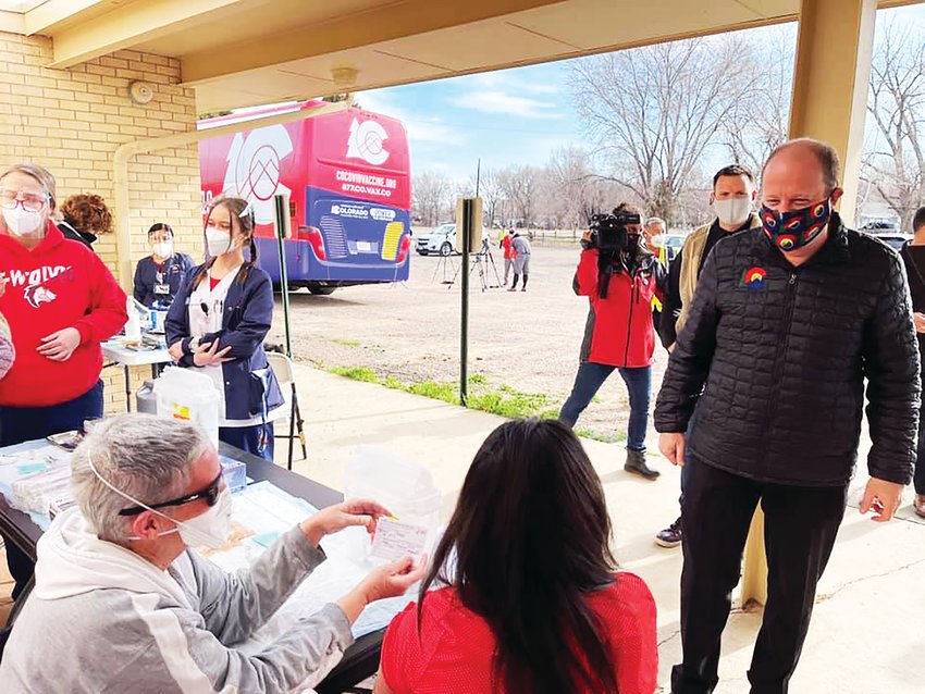 Gov. Jared Polis, right, visits a mobile vaccine clinic, an effort supported by state officials to bring vaccinations sites to locations around Colorado.