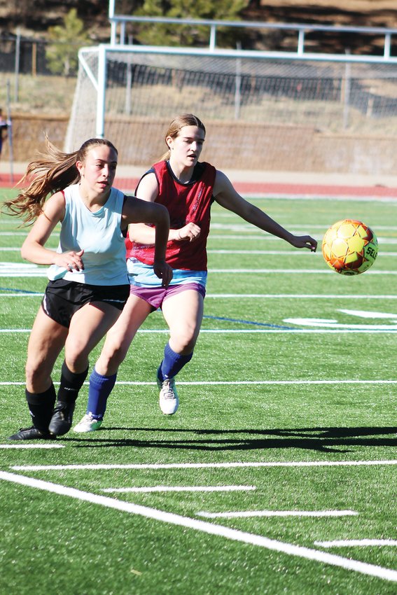 Freshman forward Trinity Cade, left, and junior midfielder Isabel Inman fight for possession of the ball after the goalie kicked it downfield during Clear Creek girls soccer practice Friday.