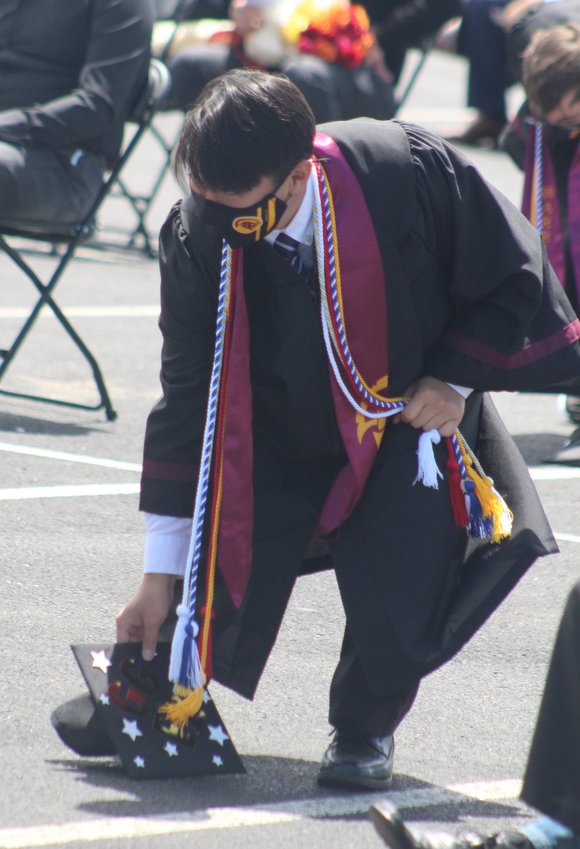 Hyunook Kim retrieves his mortar board at the conclusion of the Eagle Ridge Academy graduation program May 19.